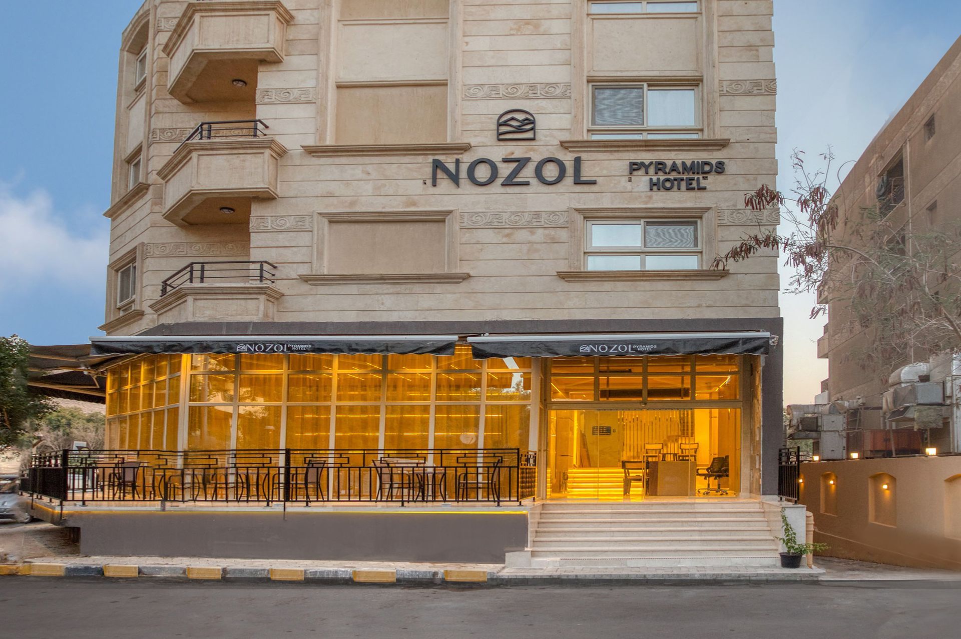 A large building with a lot of windows is sitting on the side of the road.