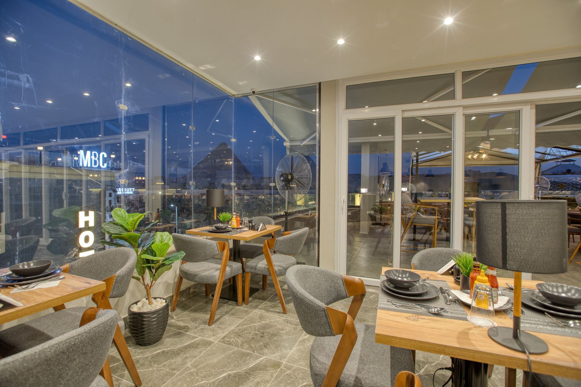 A restaurant with tables and chairs and a large window.