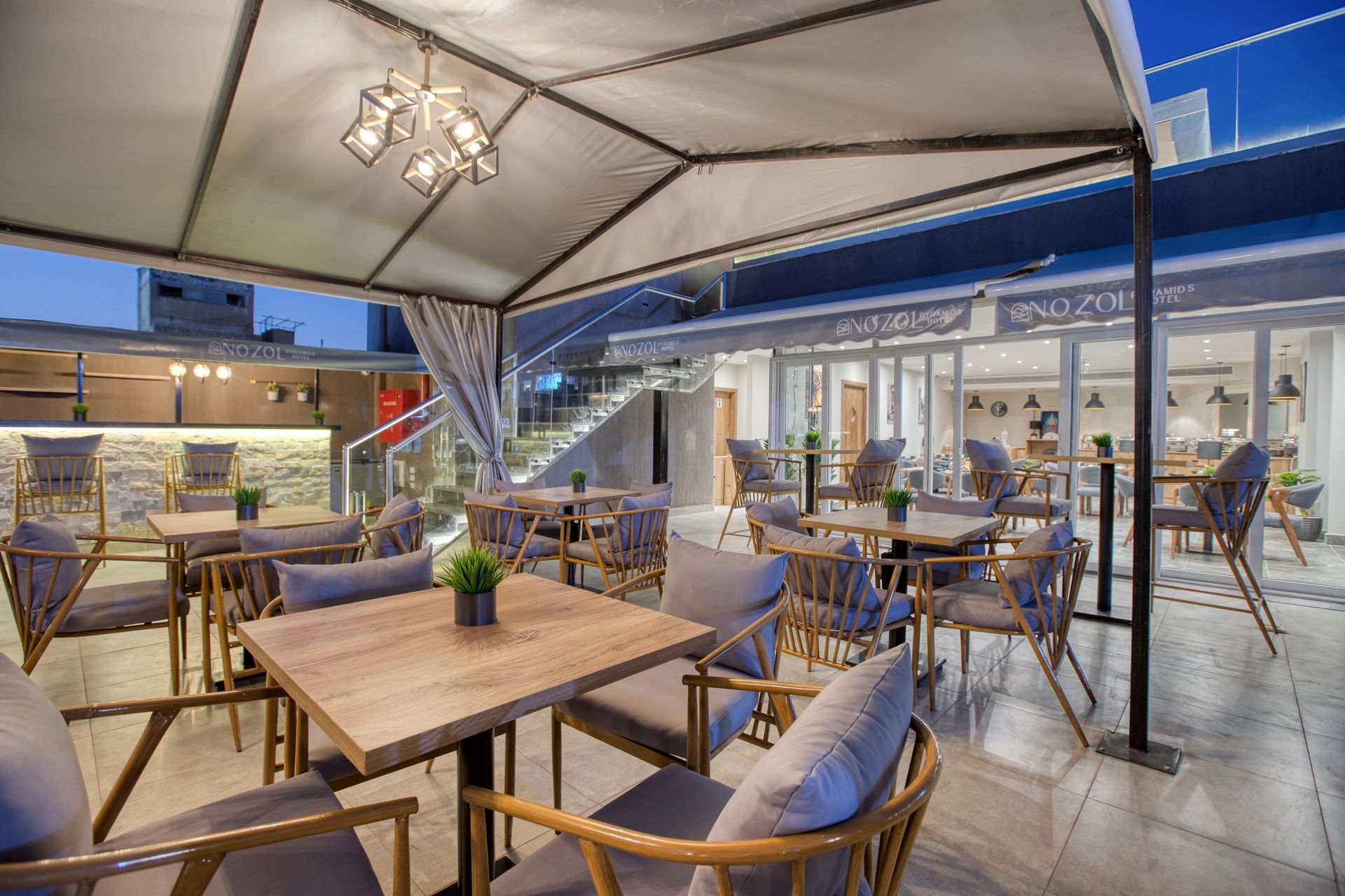 A restaurant with tables and chairs under a canopy.