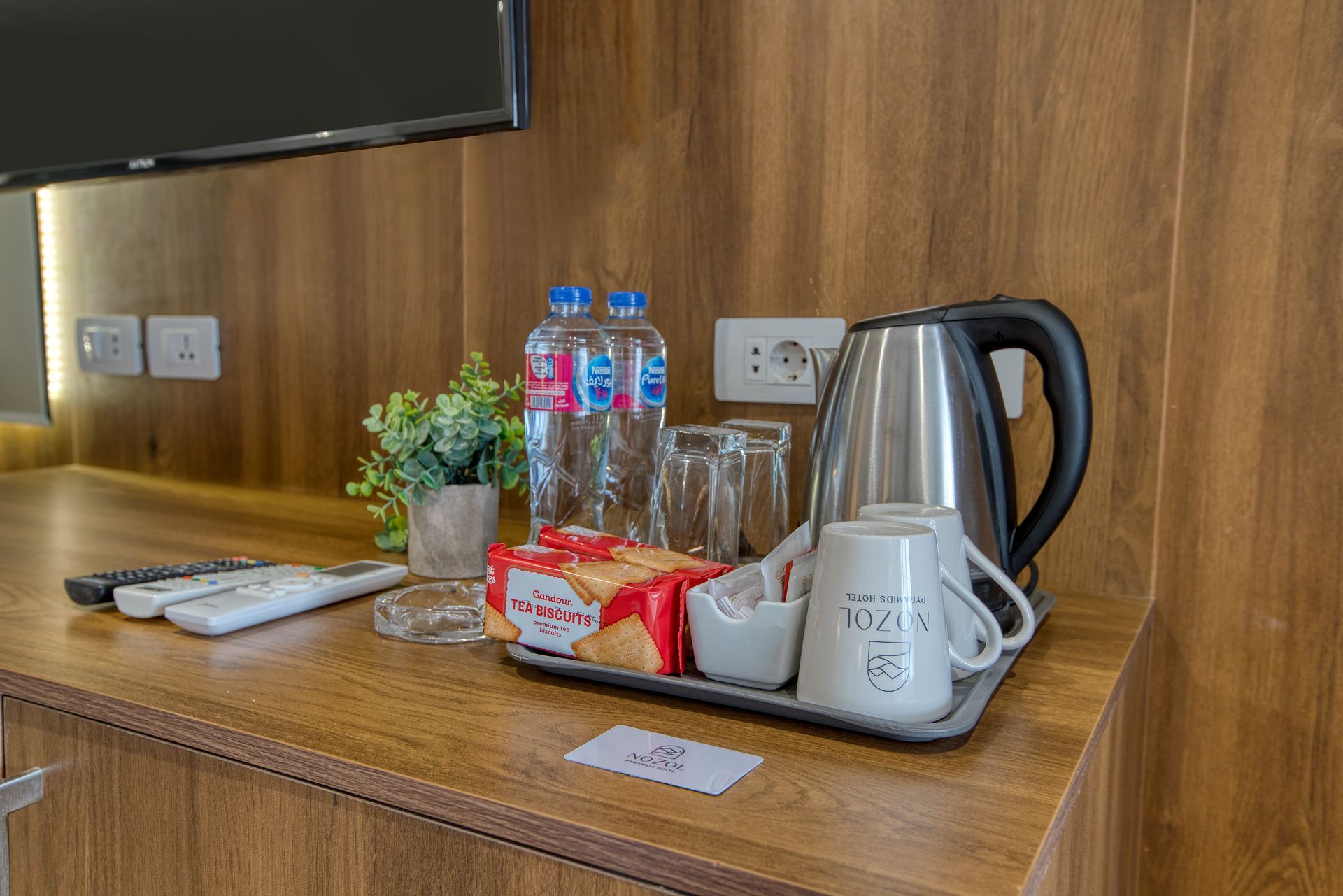 A hotel room with a tray of drinks and a kettle.
