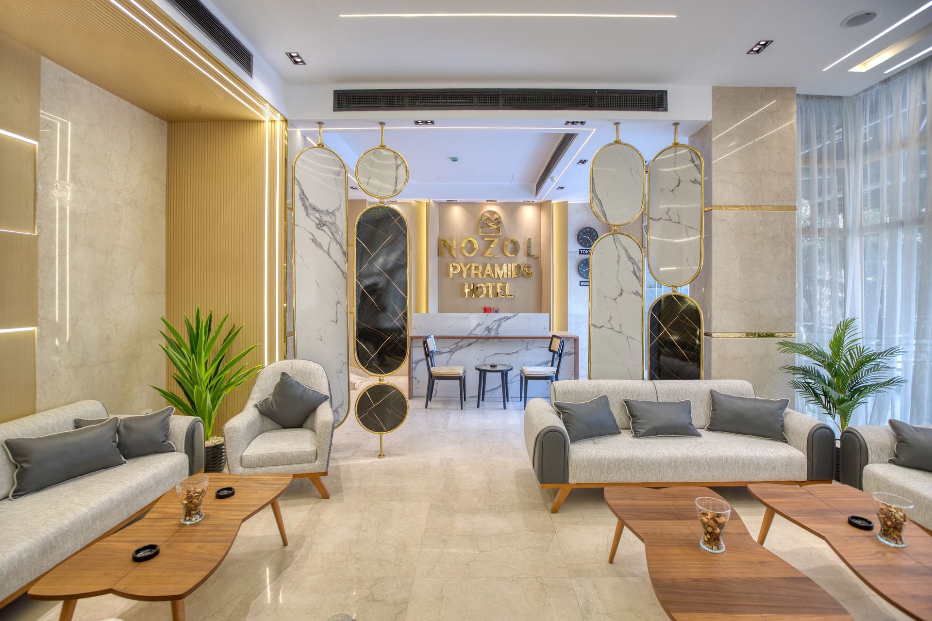 A living room with a couch , chairs , tables and a reception desk.