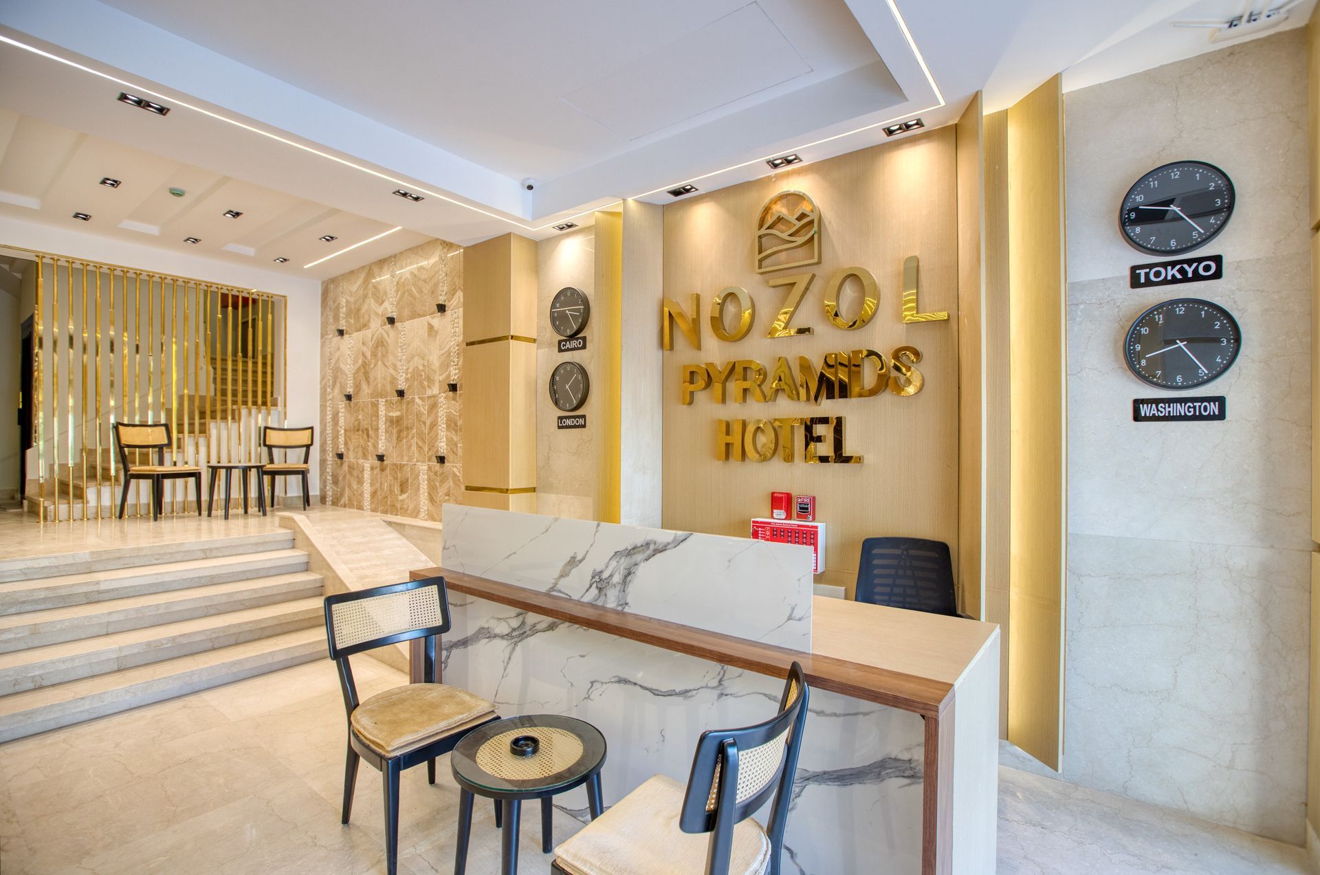 A hotel lobby with a marble counter and clocks on the wall.