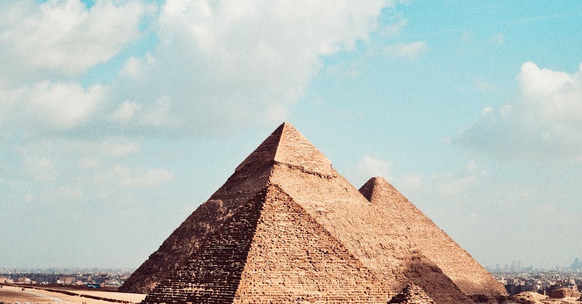 Three pyramids are stacked on top of each other in front of a blue sky.