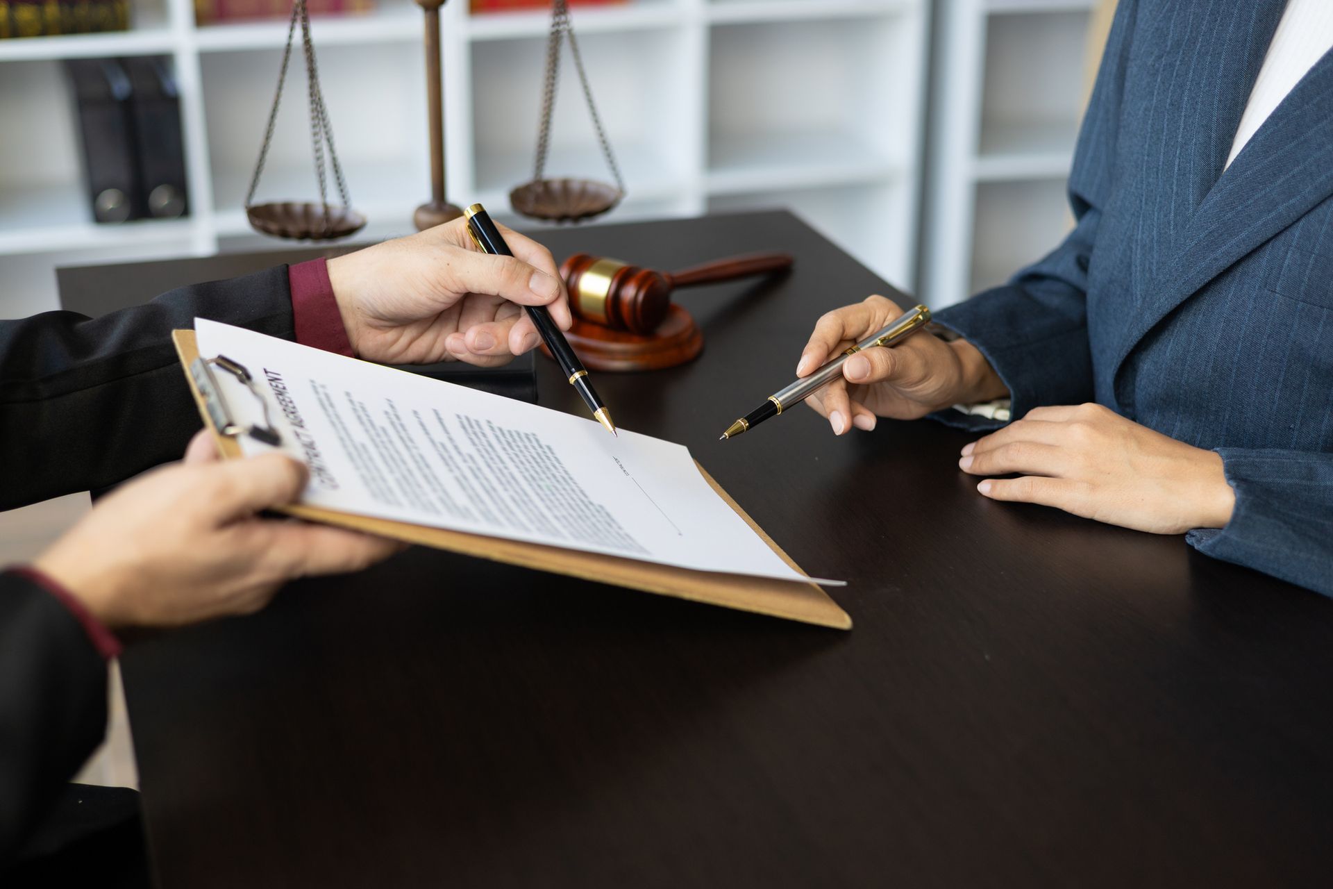 Two people are sitting at a table signing a document.