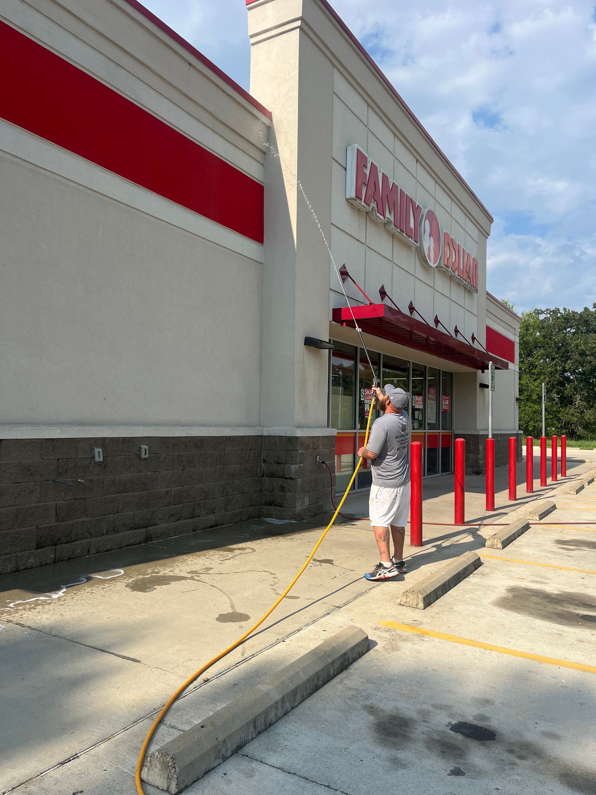 Pressure washing siding, half cleaned, showing white surface.