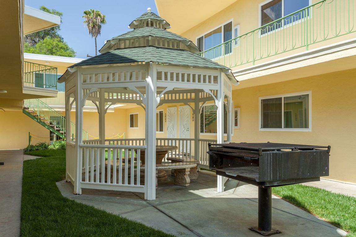 A gazebo with a grill in front of a building