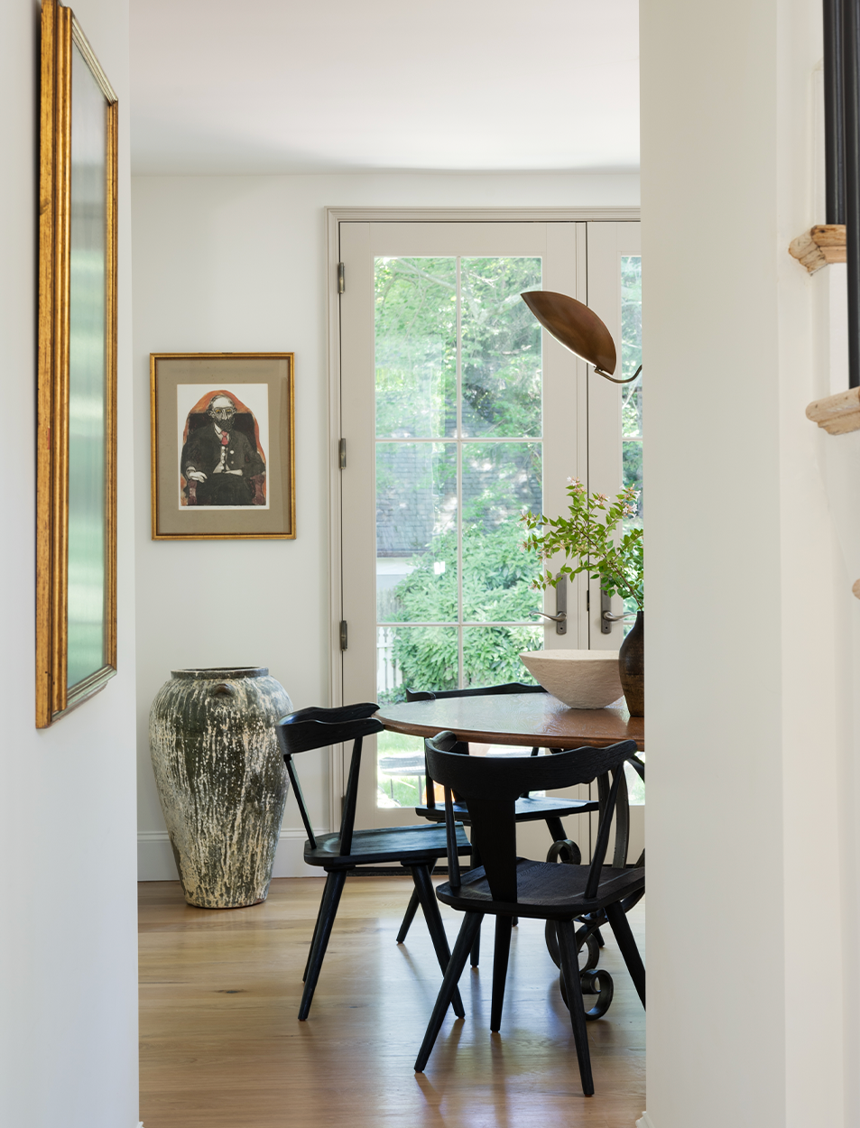 A dining room with a table and chairs and a vase