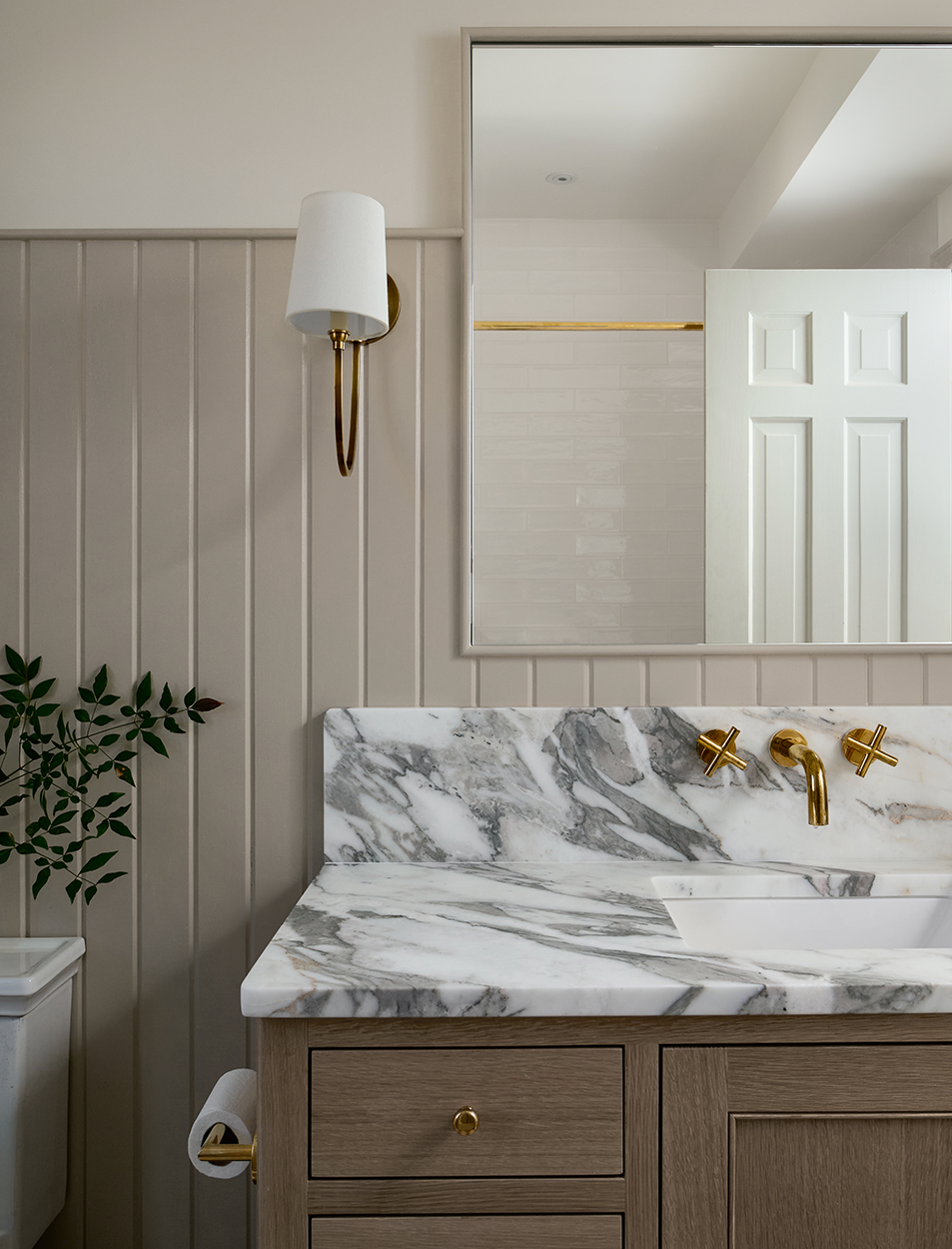 A bathroom with a sink , mirror and marble counter top.