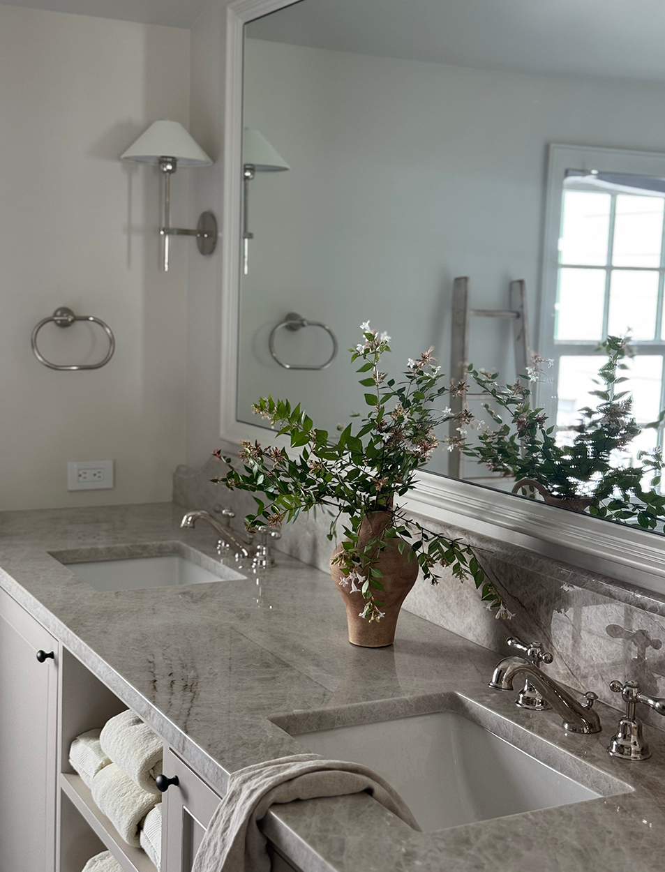 A bathroom with two sinks and a large mirror
