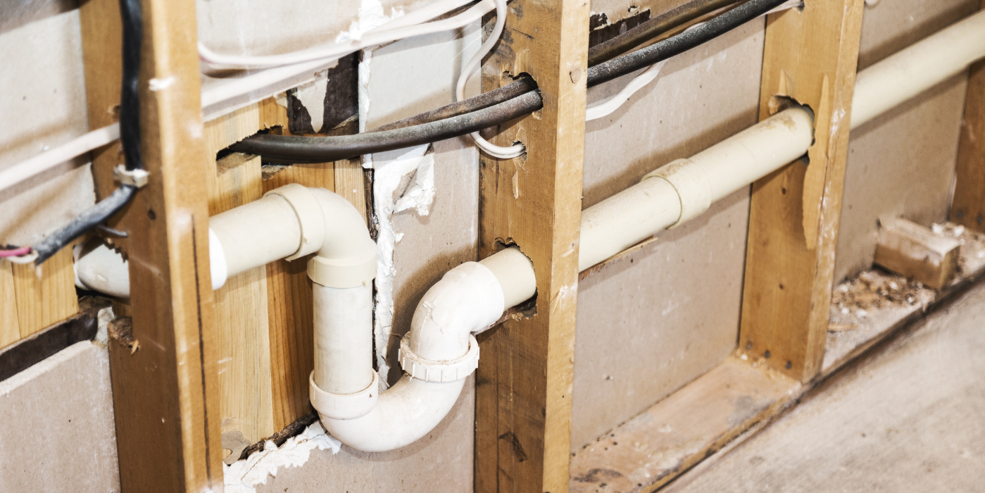 There are two chimneys on the roof of a house.