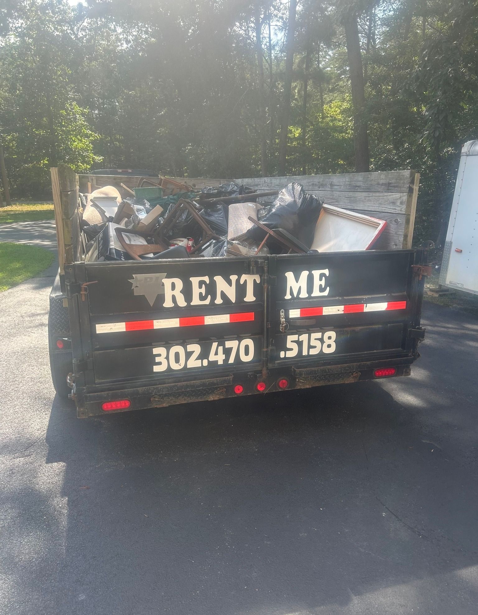 Black dumpster filled with debris; 