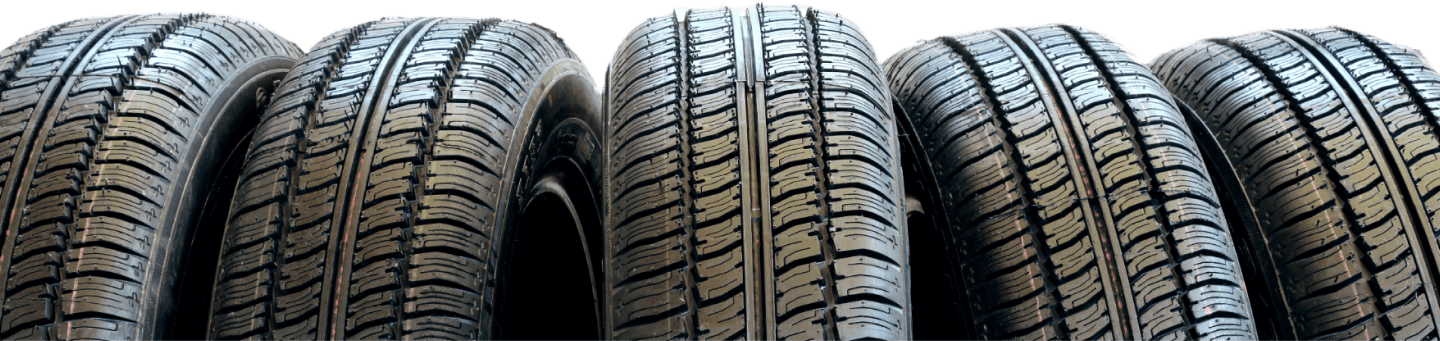 Row of black car tires with deep tread, stacked side by side | 106 St Tire and Wheel