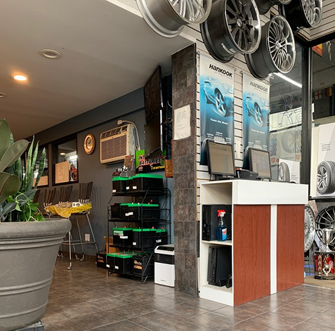 Interior of a bike shop with hanging bicycles, posters, shelves, and a front counter | 106 St Tire and Wheel