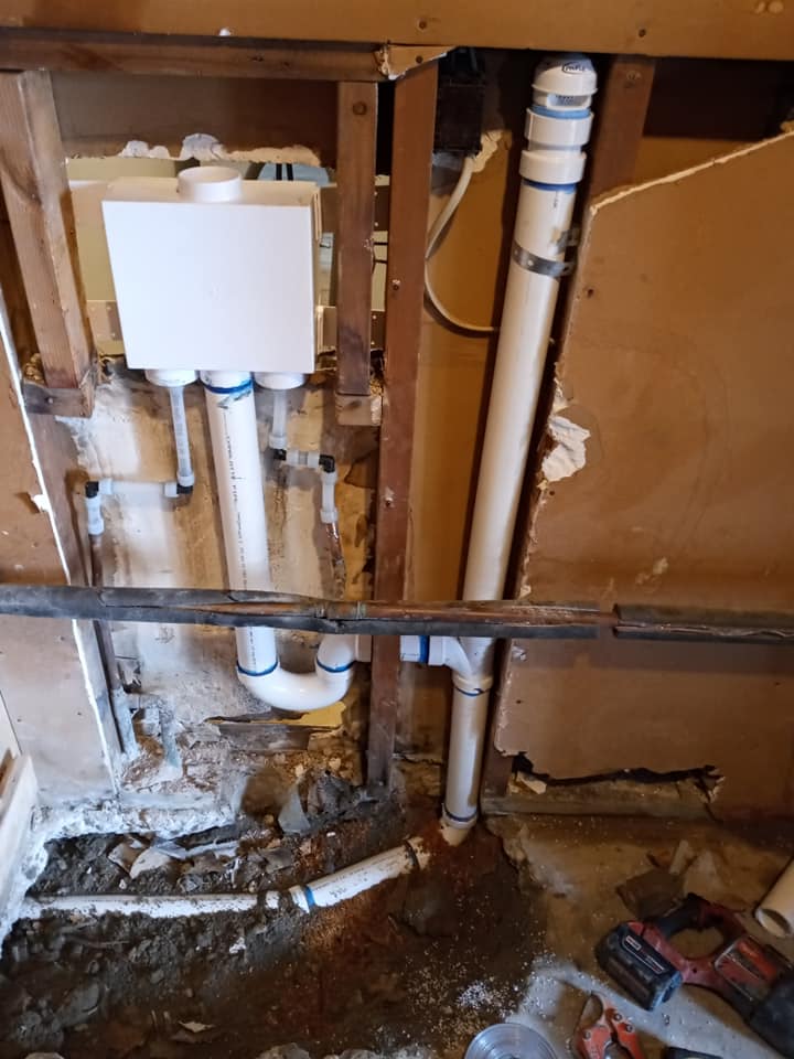 A bathroom with a lot of pipes coming out of the wall.