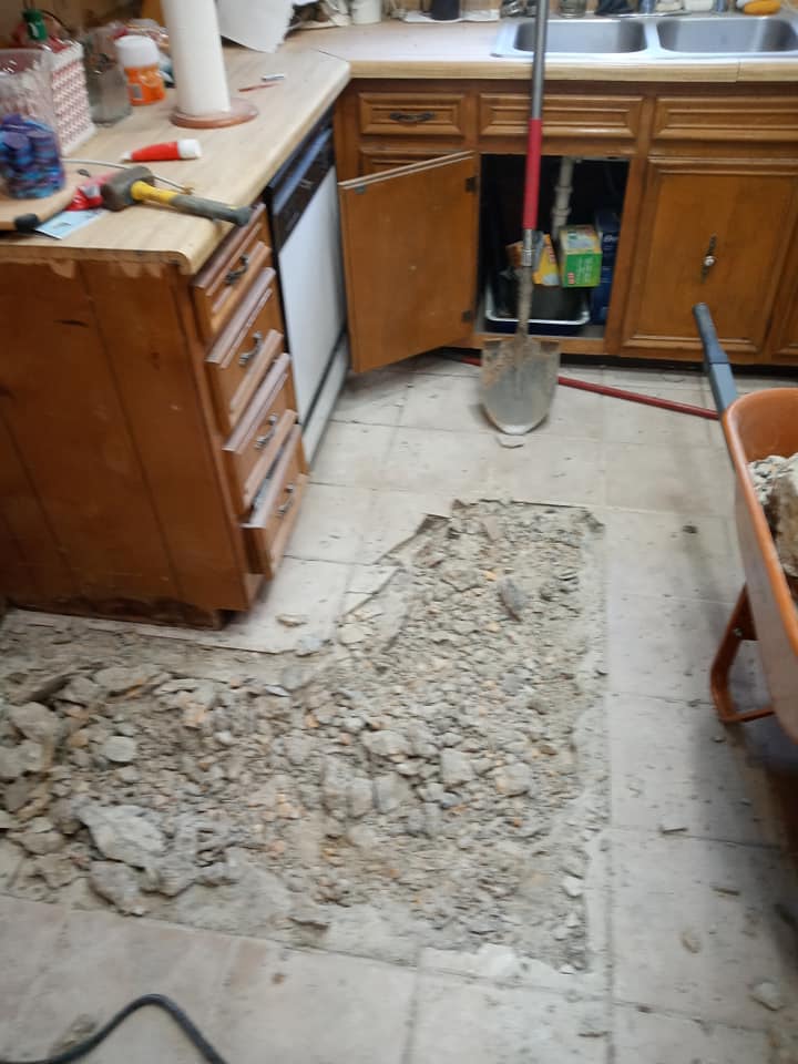 A kitchen with a shovel and a wheelbarrow on the floor