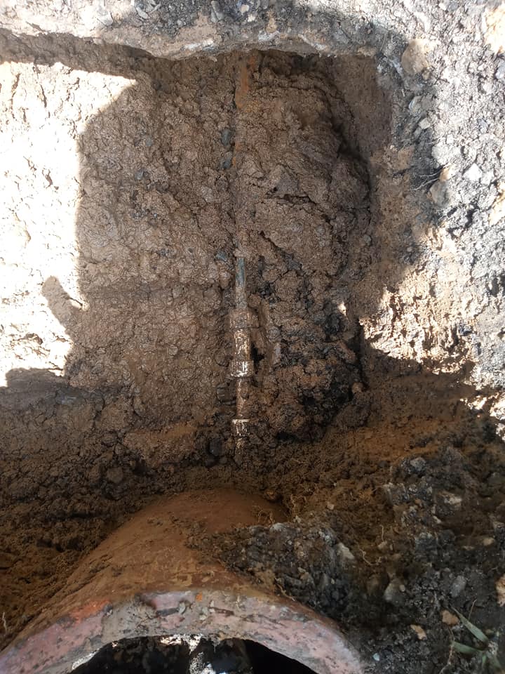 A hole in the ground with a pipe coming out of it.