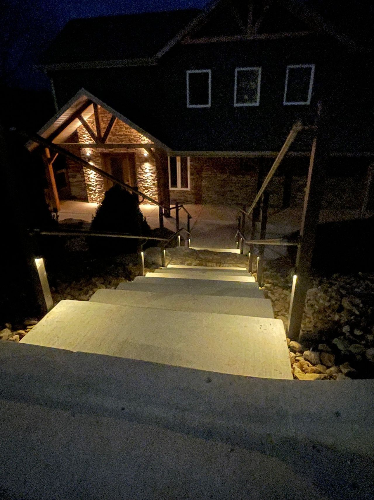 A set of stairs leading up to a house at night.
