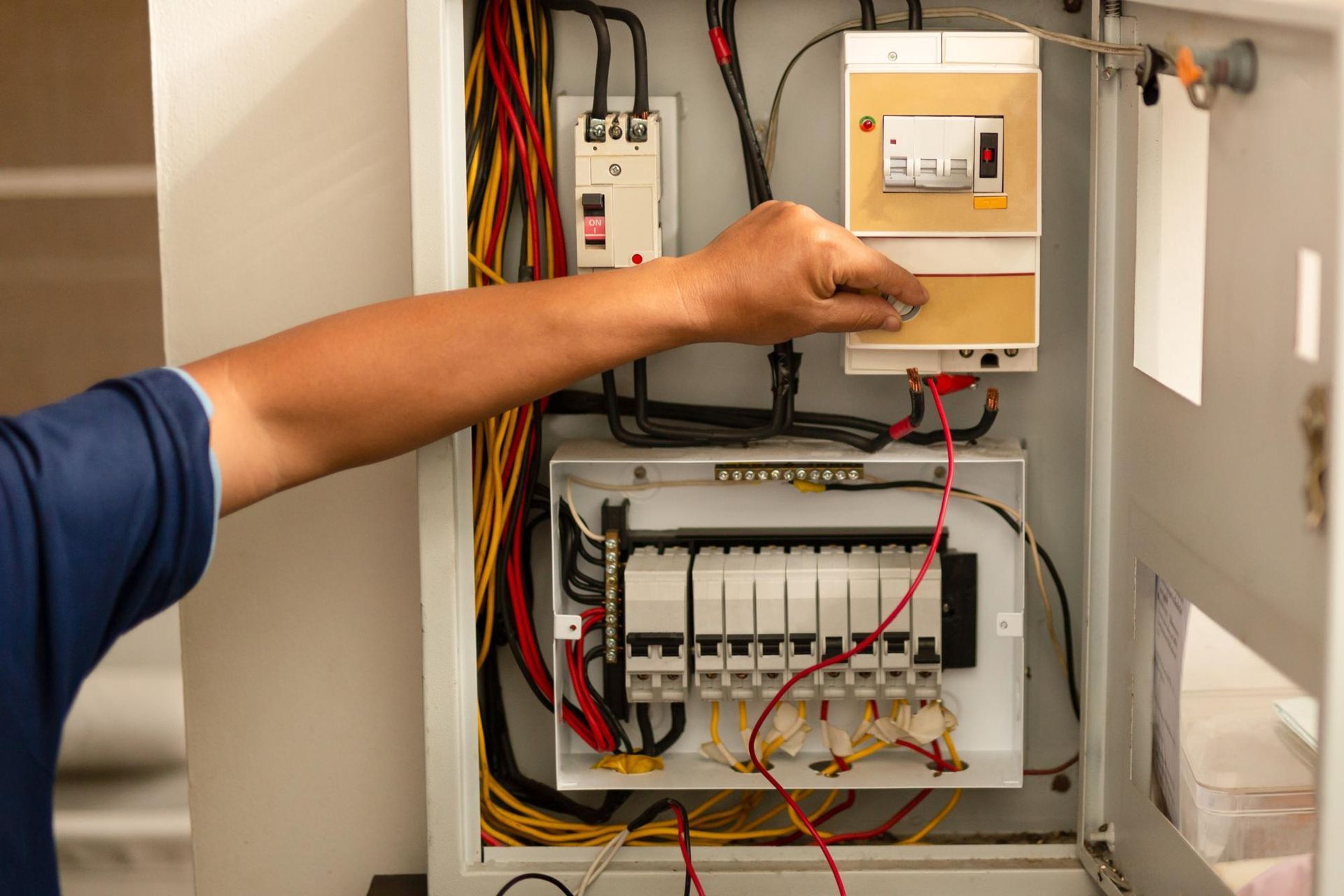 A man is working on an electrical box.
