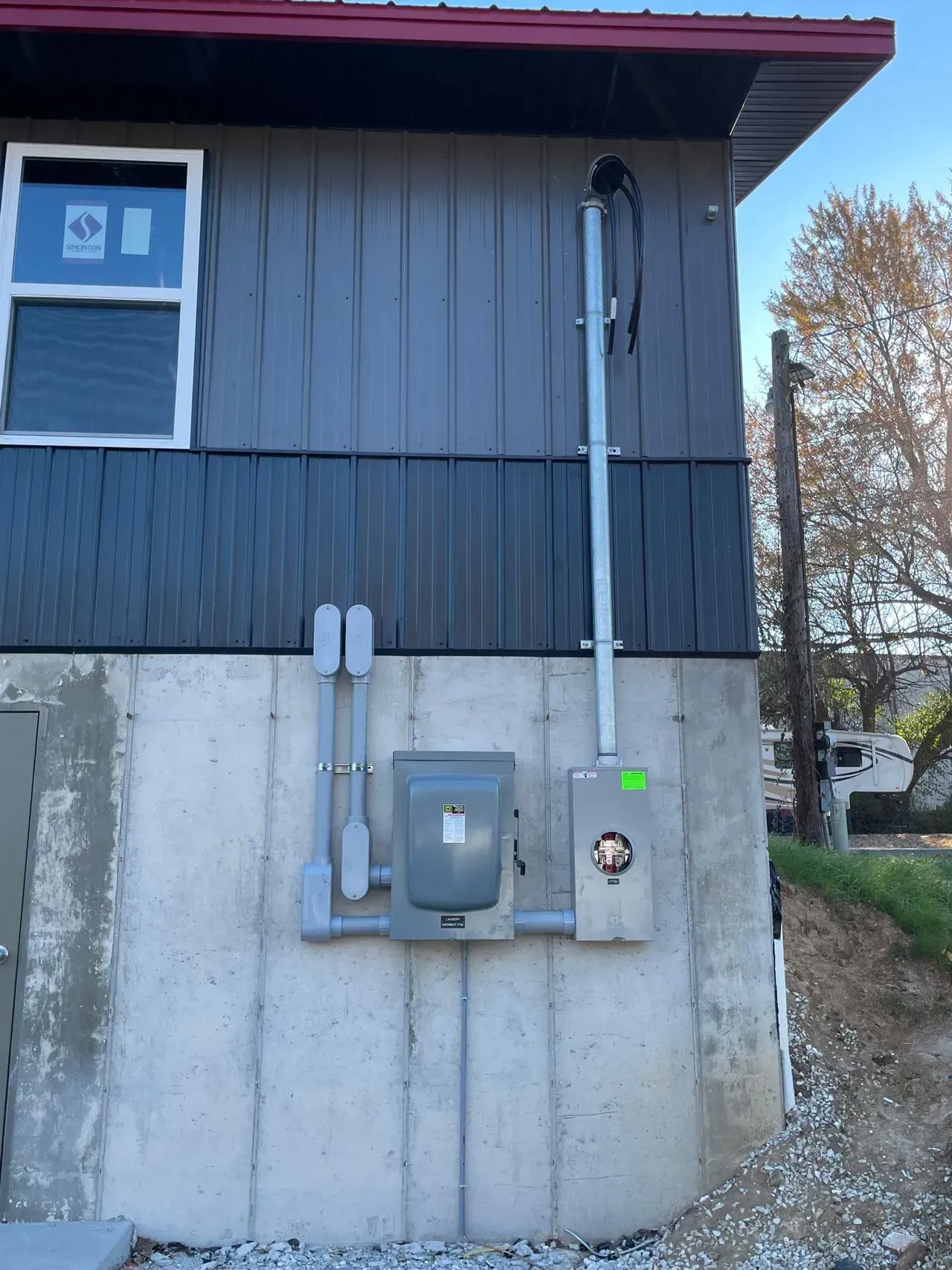 There is a box on the side of the house that looks like a mailbox.