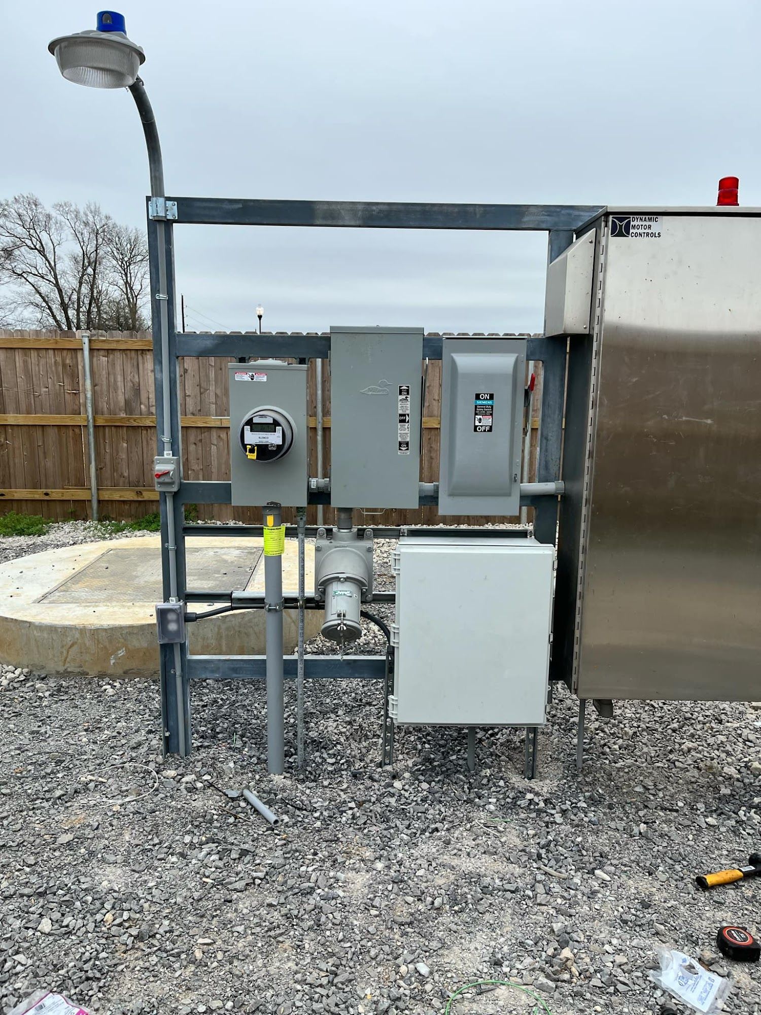 Empty parking lot under a cloudy blue sky, lit by tall streetlights.