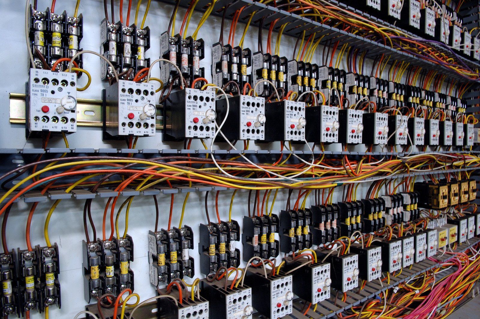 Electrical control panel with numerous wires and circuit breakers.