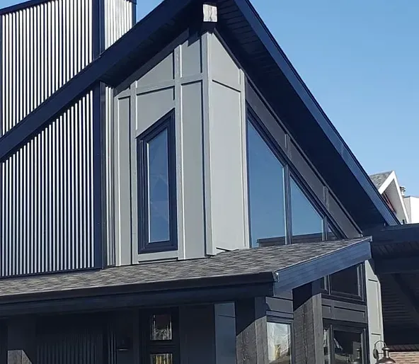 A house with a lot of windows and a black roof