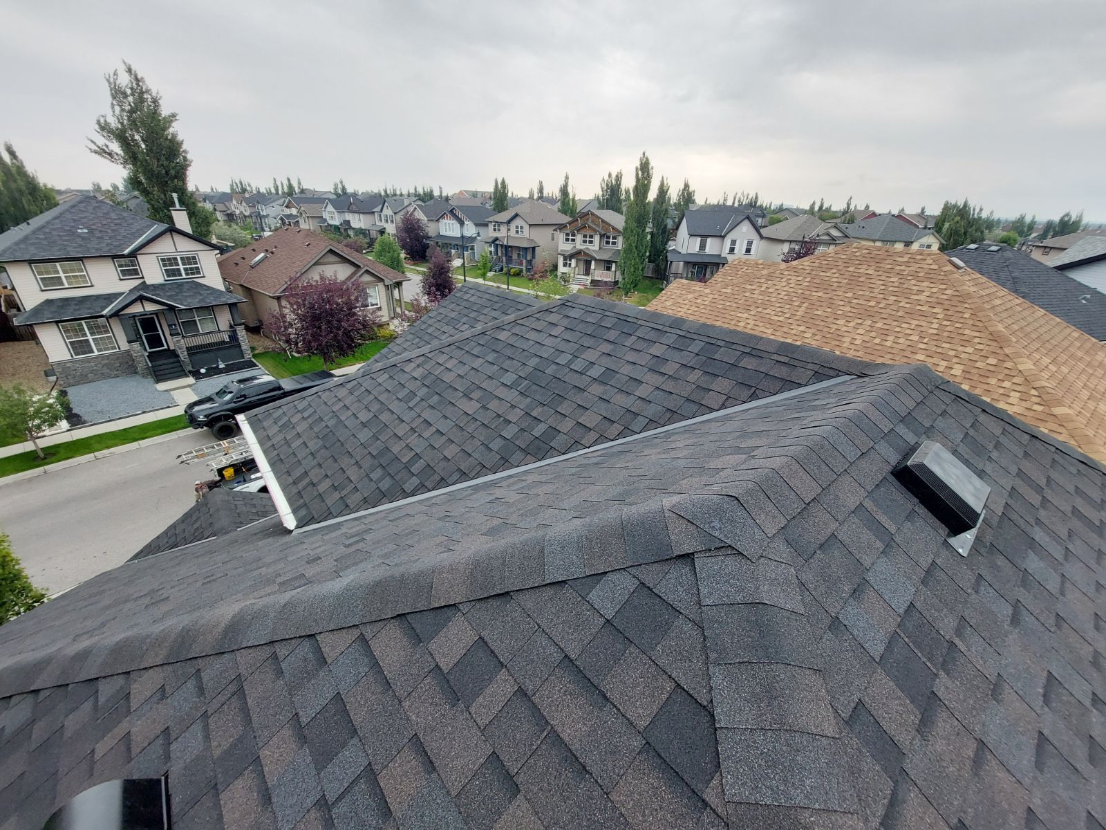 An aerial view of a roof of a house in a residential area.