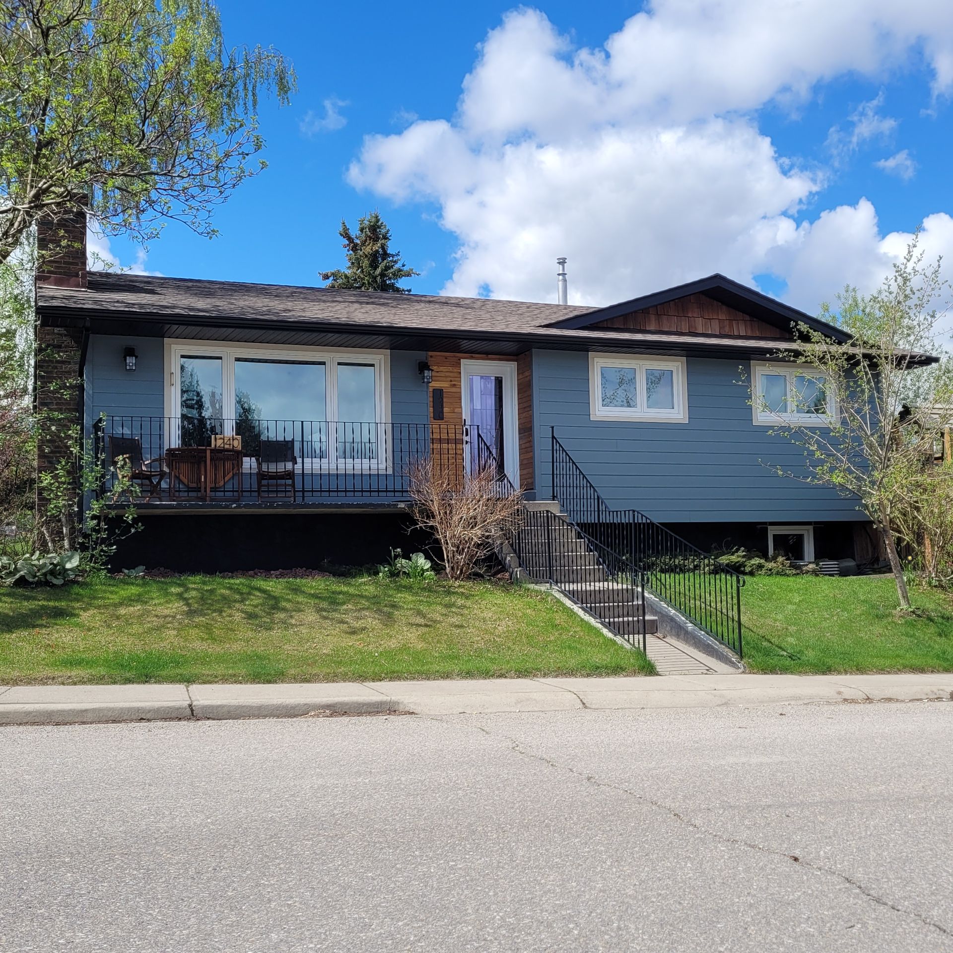 A blue house with stairs leading up to the front door