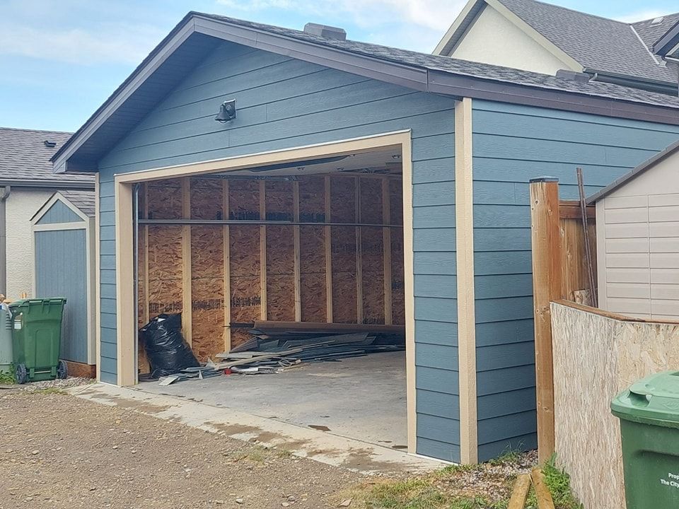 A garage is being built in the backyard of a house.