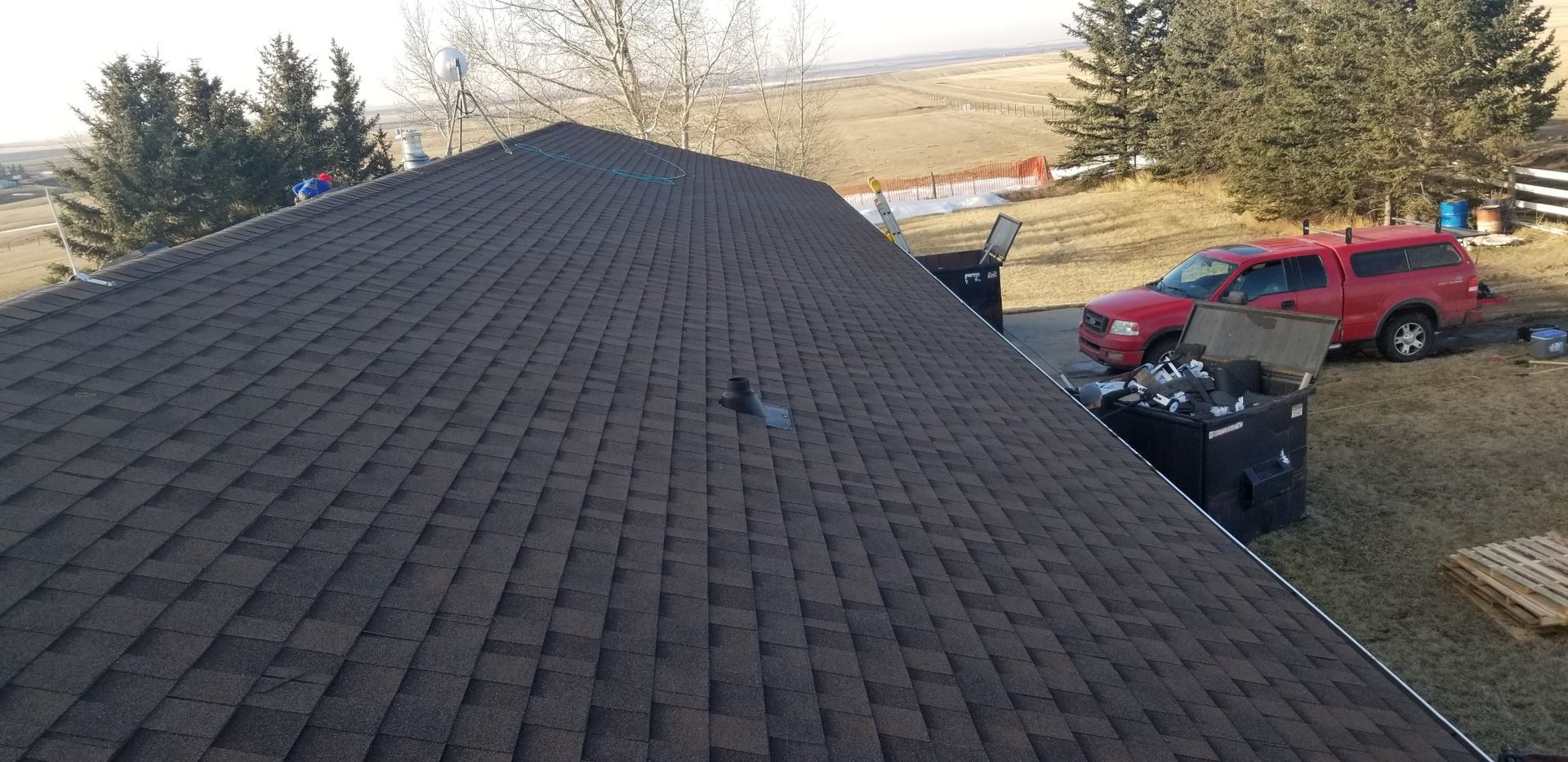 A red truck is parked on the roof of a house.