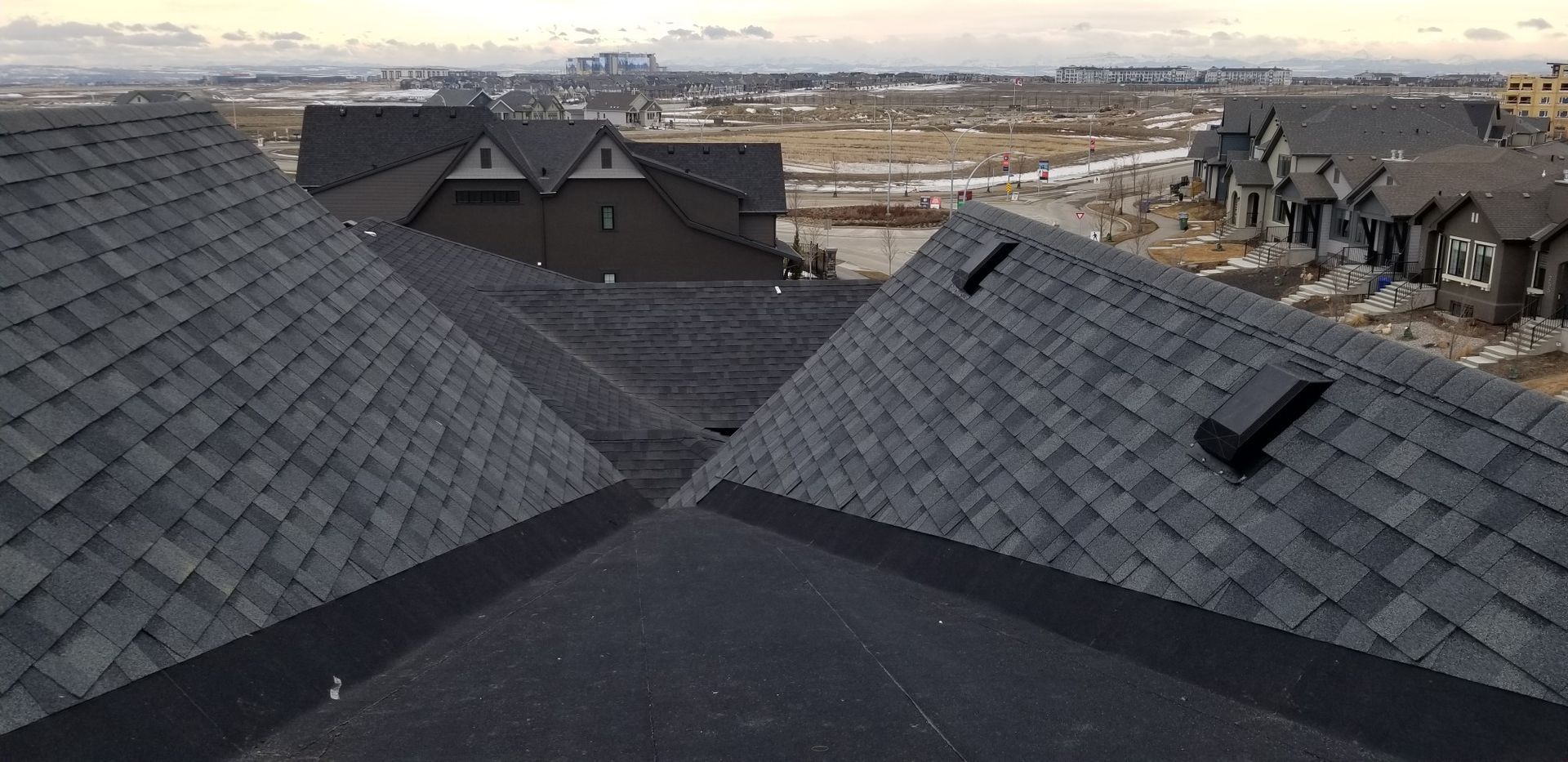 A roof with a lot of shingles on it and a lot of houses in the background.