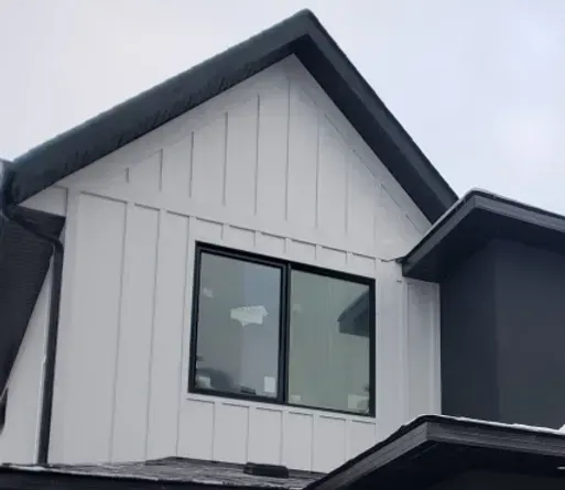 A black and white house with a black roof and a window.