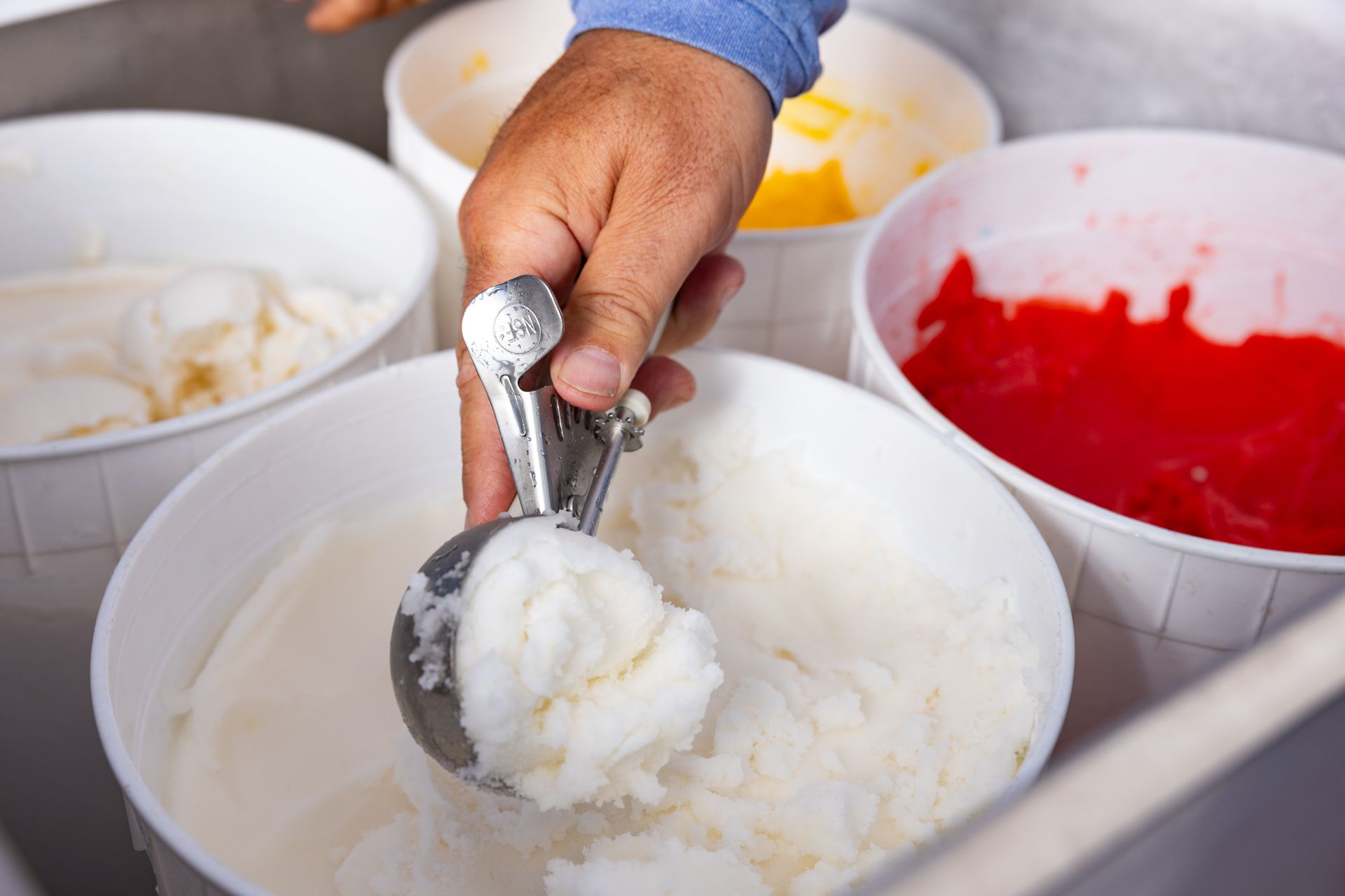 A person is scooping ice cream from a bowl