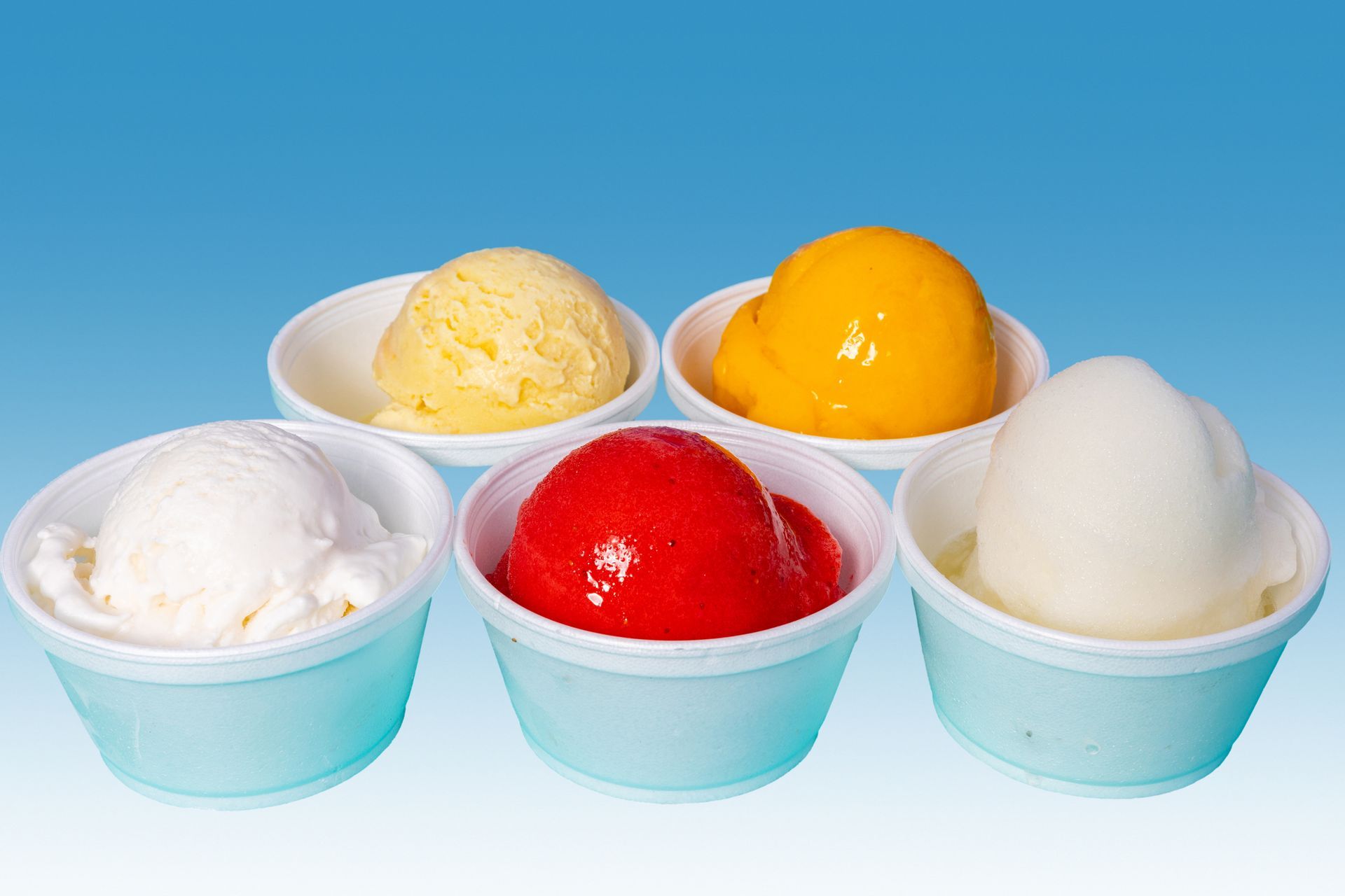 Five bowls of different flavors of ice cream on a blue background