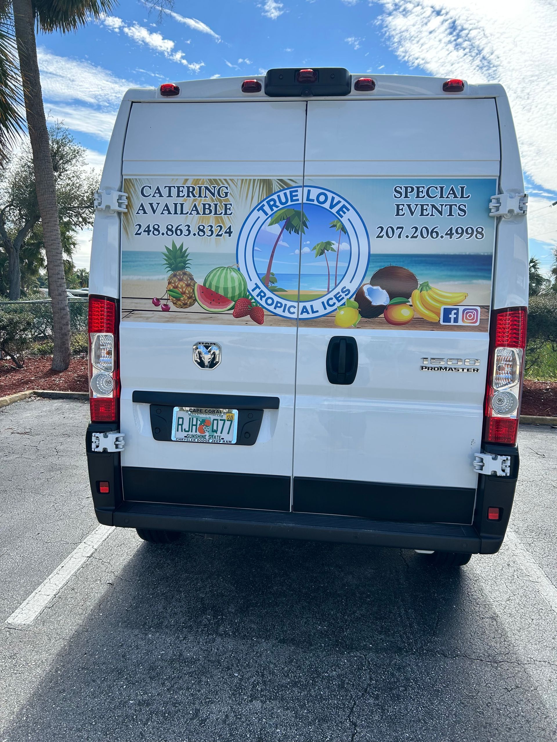 The back of a white van is parked in a parking lot.