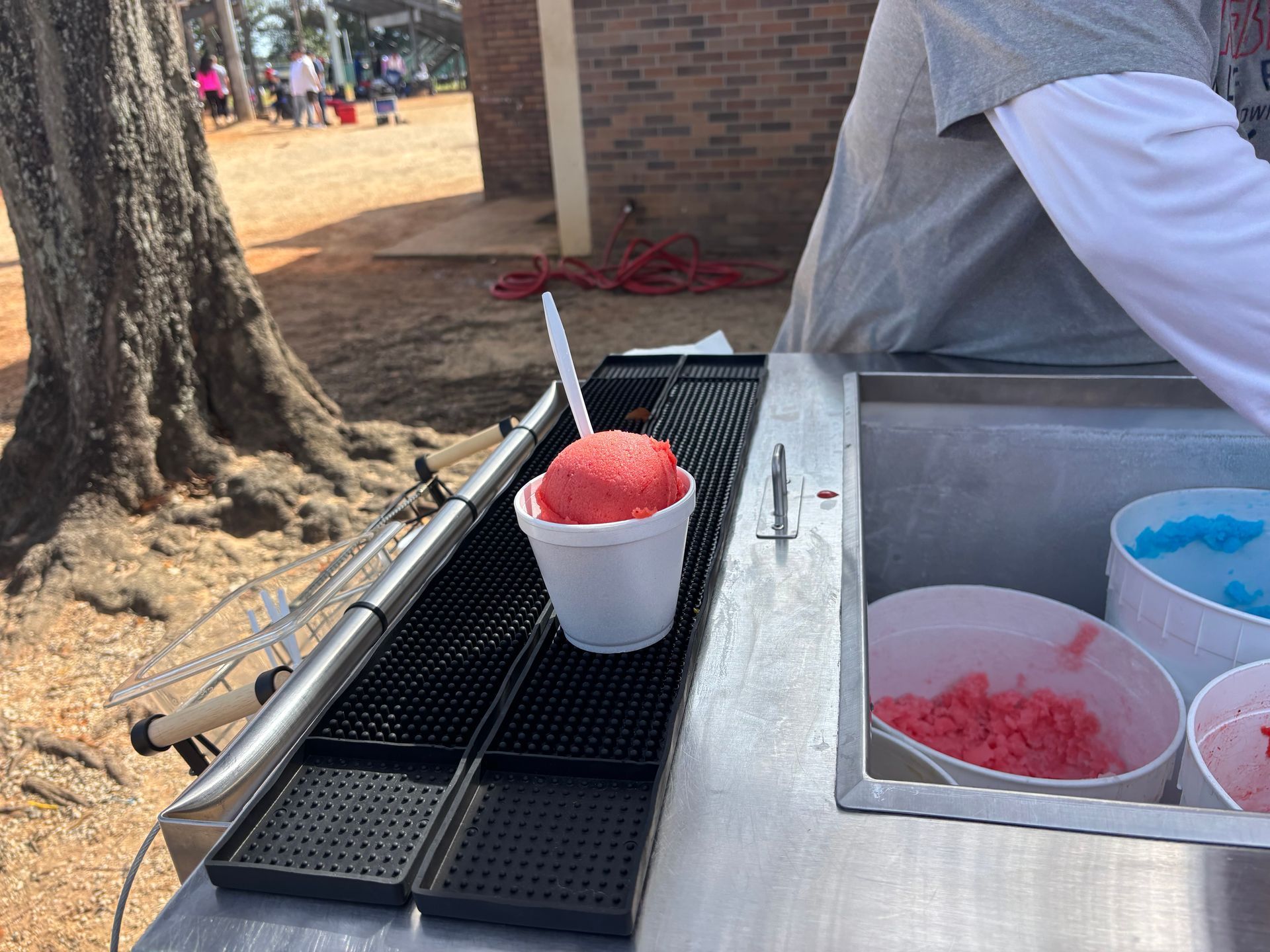 A cup of shaved ice is sitting on a counter.