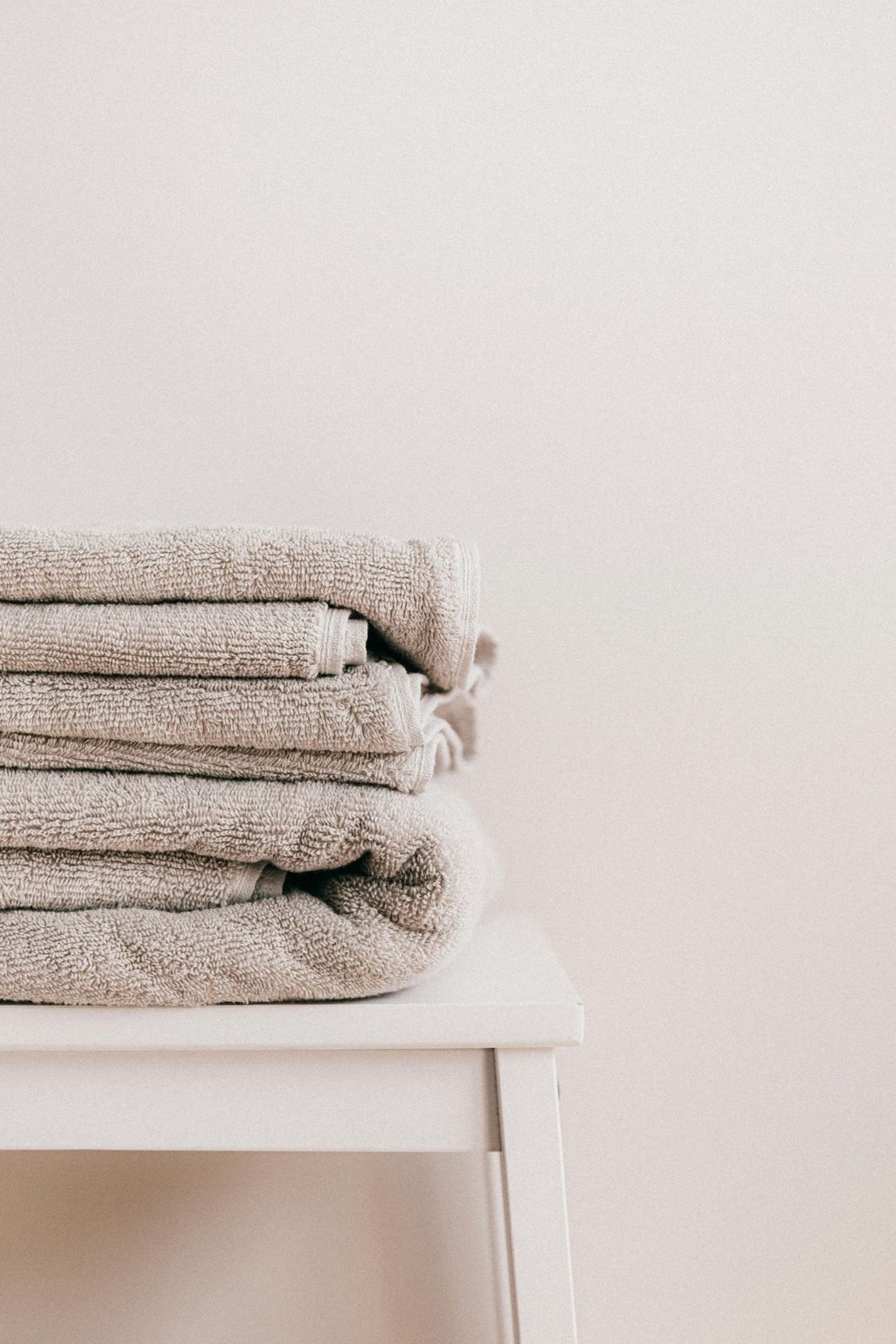 A bed with white sheets and pillows on it.