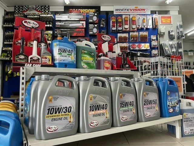A Row Of Bottles Of Oil Are Lined Up On A Shelf In A Store — Townsville Wholesale Panel & Parts In Garbutt, QLD