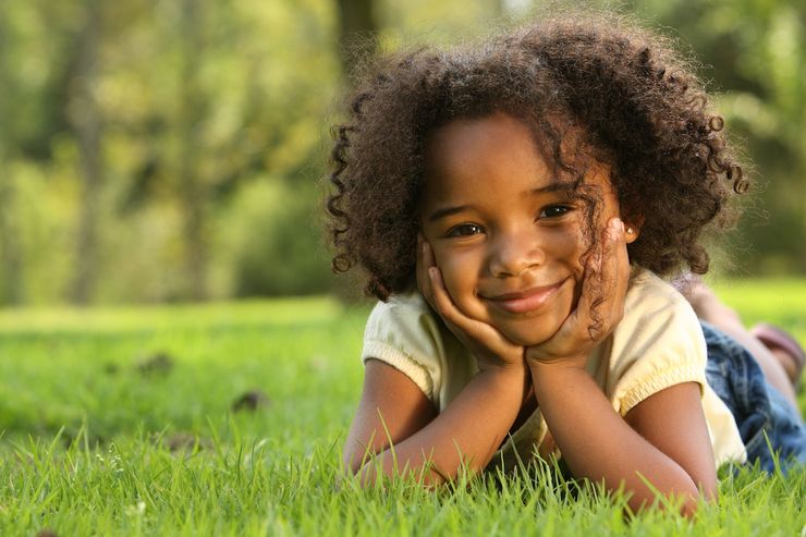 Little girl smiling in grass photo