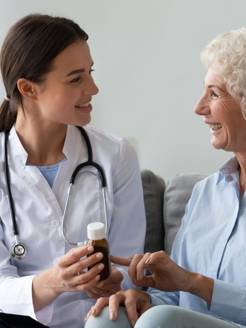 A pharmacist giving an elderly woman a medicine