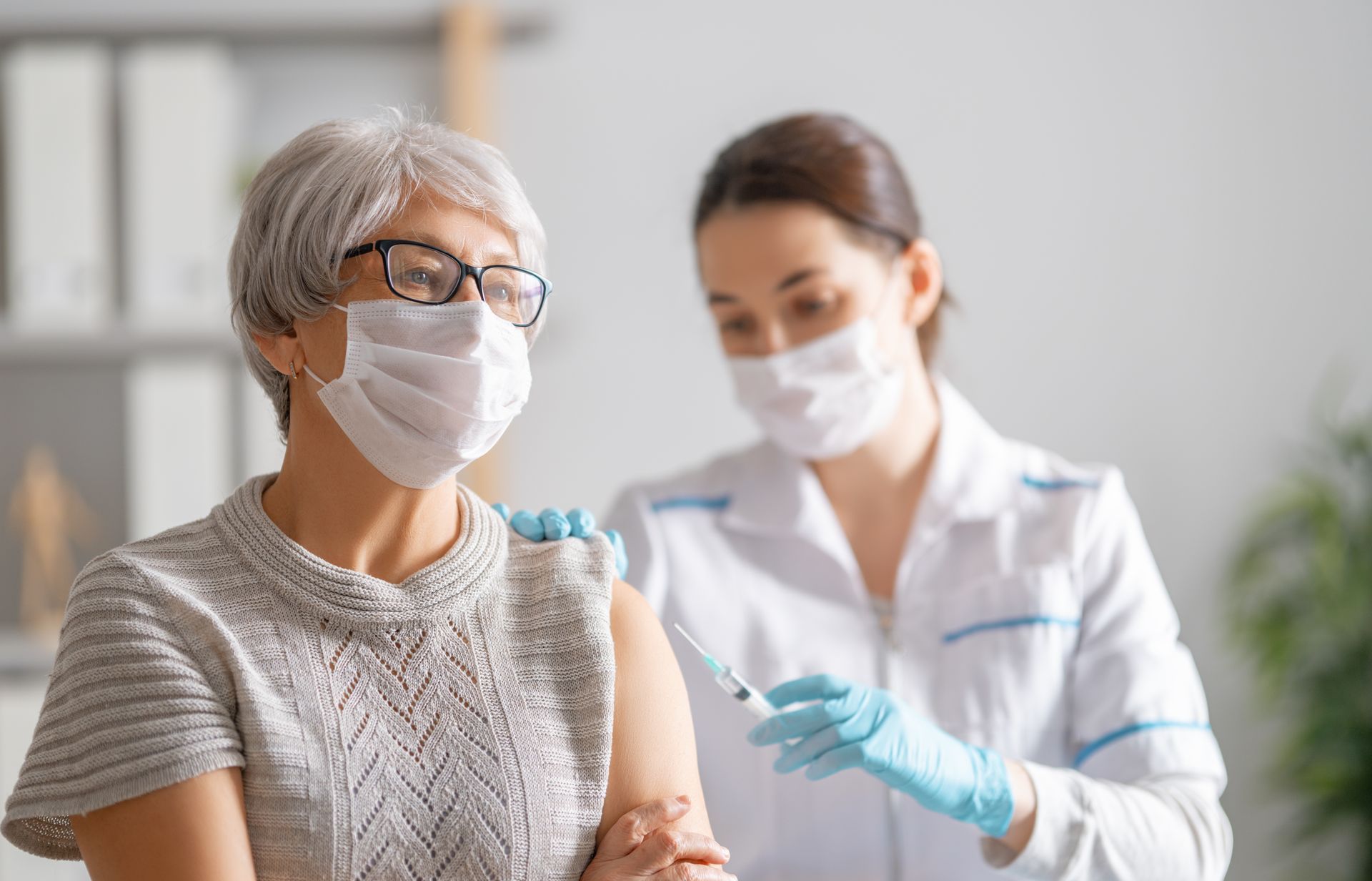 A pharmacist giving an elderly woman a vaccine