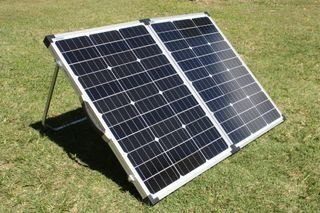 A Solar Panel Is Sitting On Top Of A Lush Green Field — Rainbow Beach Auto Electrics In Rainbow Beach, QLD