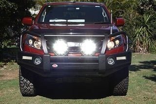 A Red Truck With Lights On The Front Is Parked In The Grass — Rainbow Beach Auto Electrics In Rainbow Beach, QLD