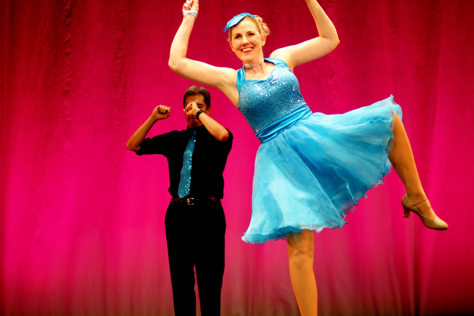 a man and a woman are dancing on a stage .