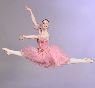 a ballerina in a pink tutu is jumping in the air .
