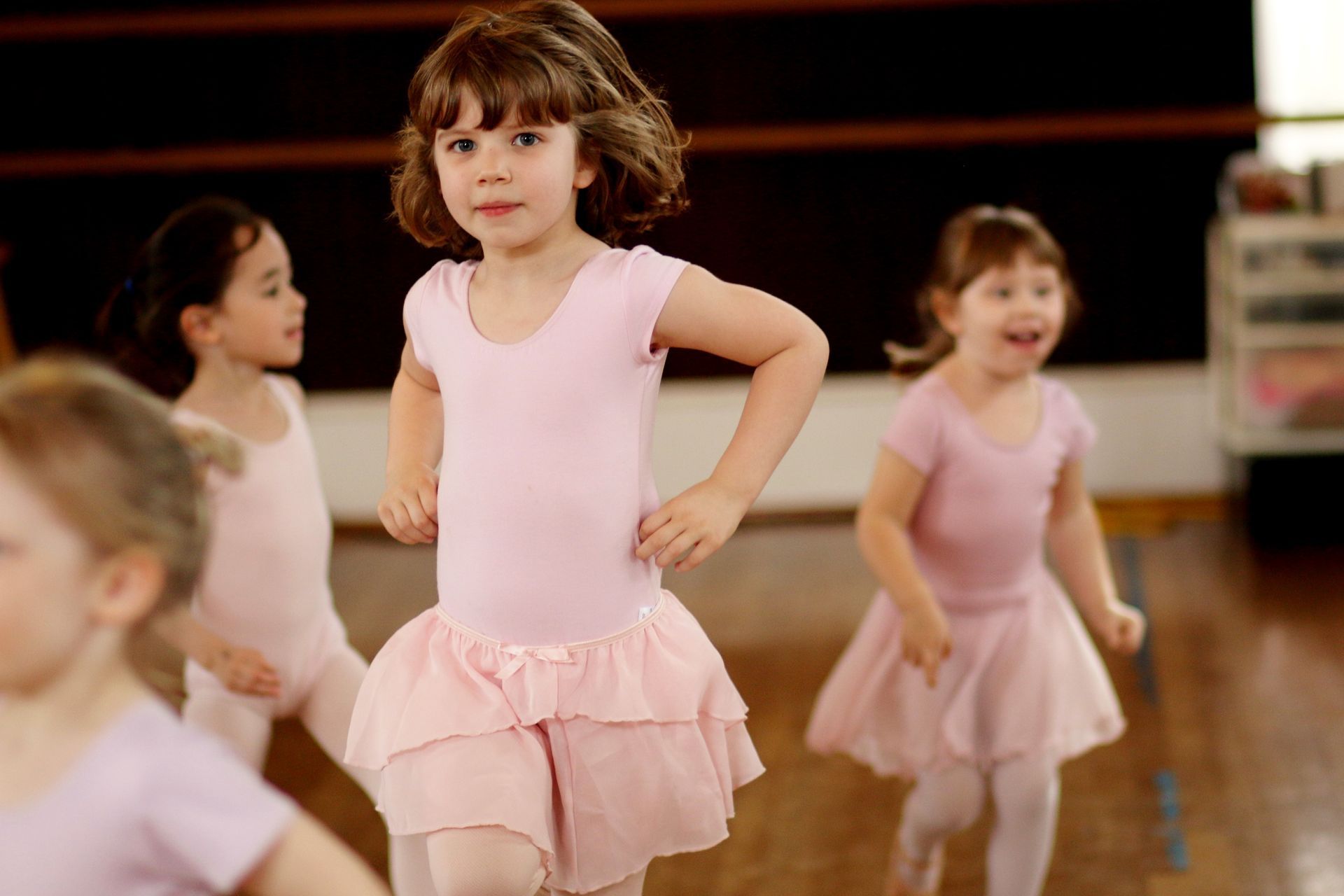 a group of young girls are dancing in a dance studio .