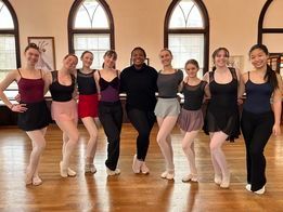 a group of young women are posing for a picture in a dance studio .
