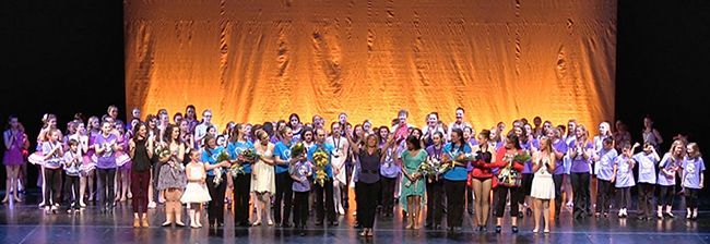 a large group of people are standing on a stage .