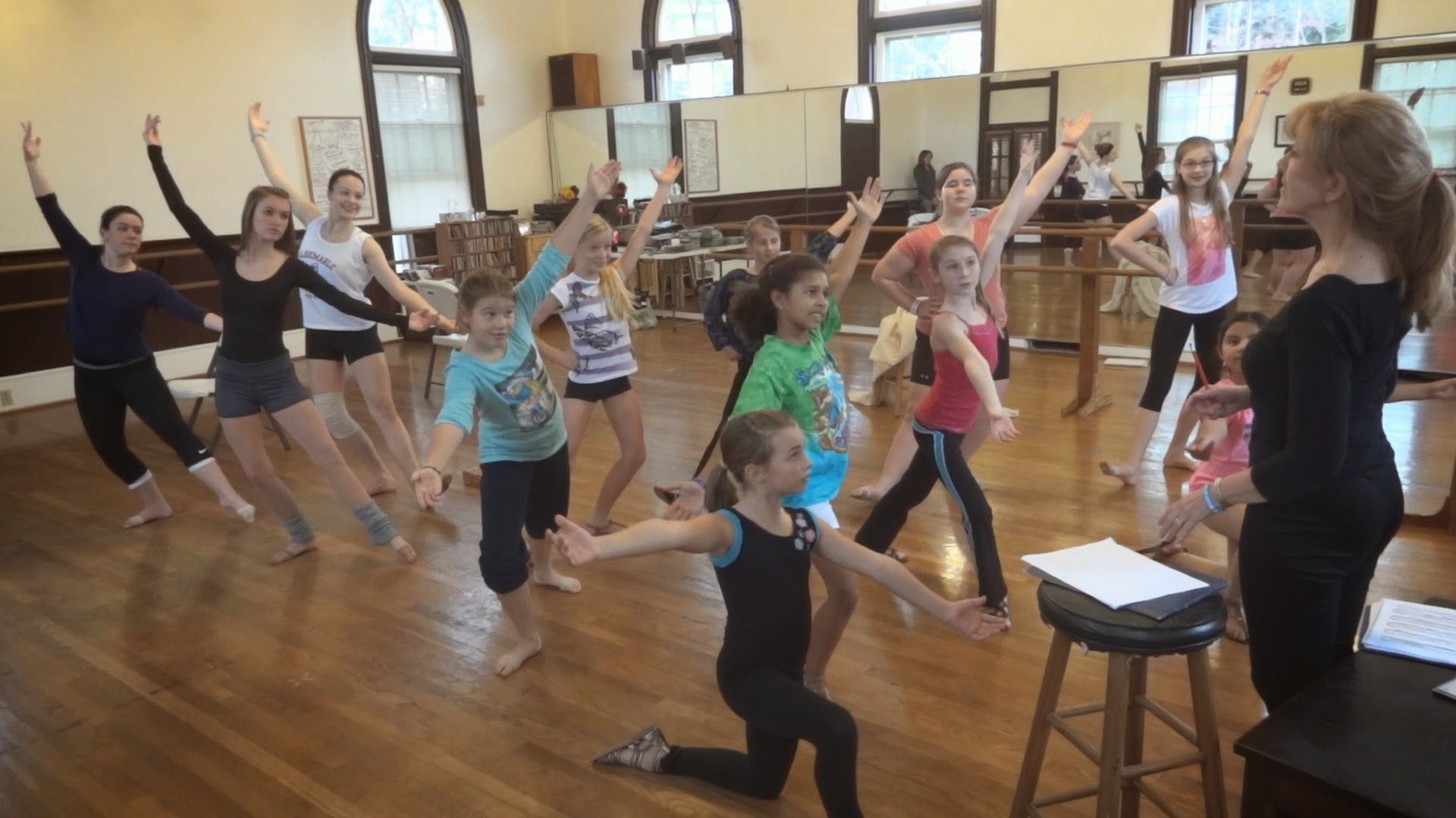 a group of young girls are dancing in a dance studio