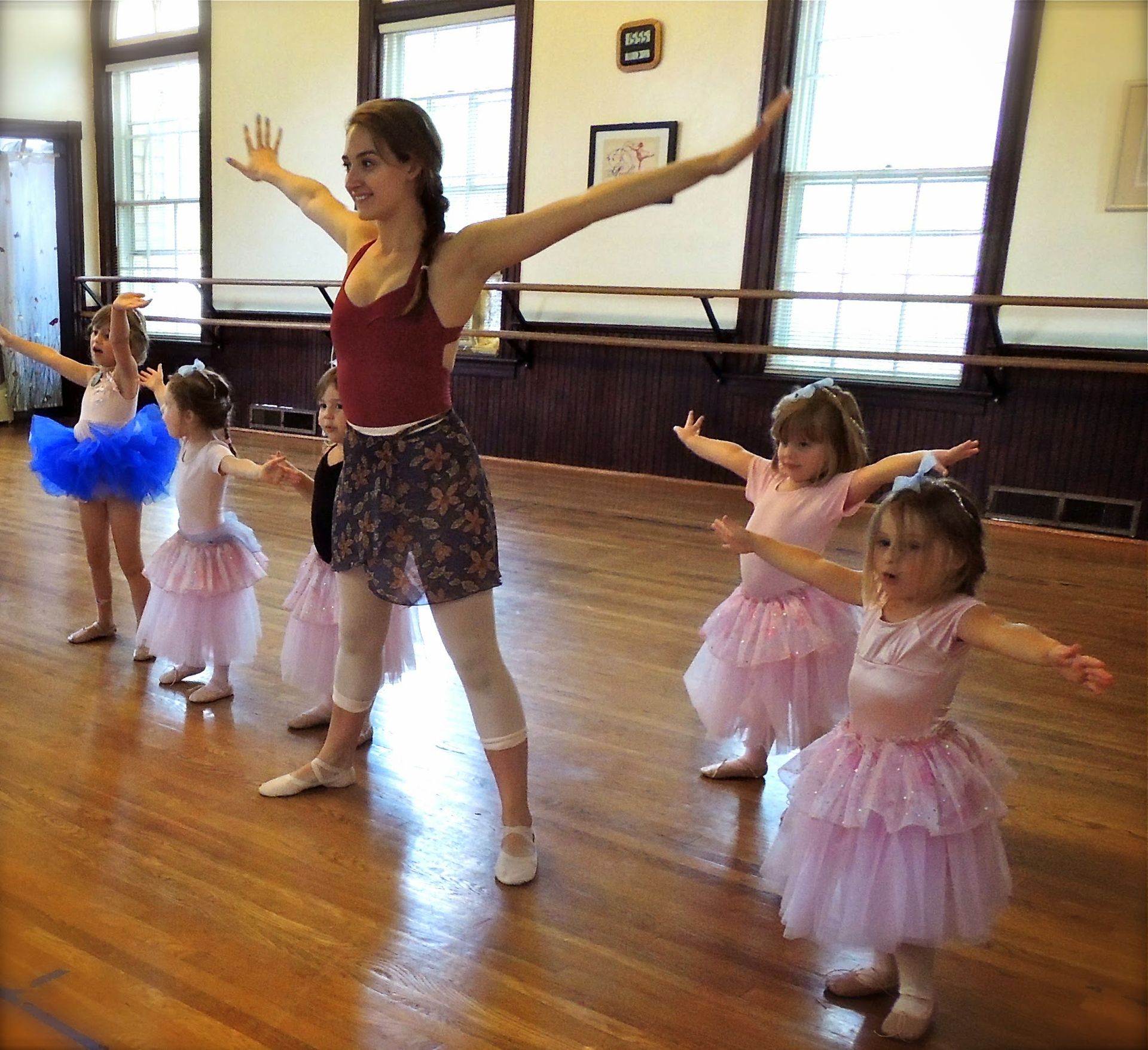 a woman is teaching a group of young girls how to dance